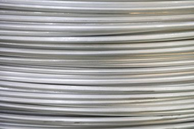 Pürüzsüz bir yüzeye sahip sarmal alüminyum kabloların yakın çekimi ve katmanlı örtüşen desen, yumuşak ışıklandırma.