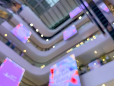 Hareketli bir alışveriş merkezinin bulanık görüntüsü modern bir perakende satış ortamının canlı atmosferini yakalıyor. İnsanlar alışveriş yaparken görülüyor.