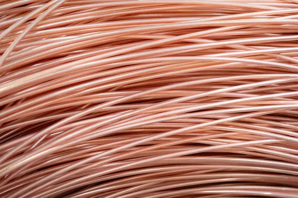 Parlak yüzeyi olan sarmalanmış bakır kabloların yakın çekimi, karmaşık örtüşen desenler, sıcak ışıklandırma..
