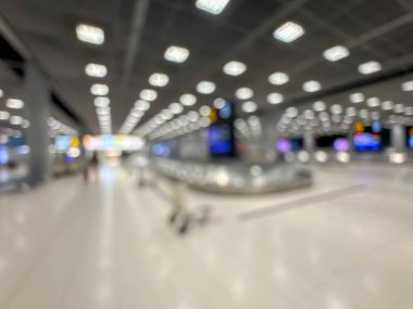 Havaalanı terminalinin bulanık görüntüsü, beklenti ve seyahat duygusunu yakalıyor. Resim boş bir bagaj teslim alanını gösteriyor