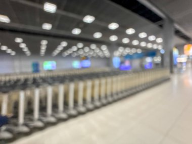 Havaalanı terminalinin bulanık görüntüsü, beklenti ve seyahat duygusunu yakalıyor. Resim boş bir bagaj teslim alanını gösteriyor