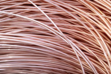 Parlak yüzeyi olan sarmalanmış bakır kabloların yakın çekimi, karmaşık örtüşen desenler, sıcak ışıklandırma..