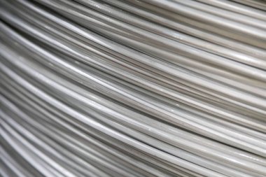 Pürüzsüz bir yüzeye sahip sarmal alüminyum kabloların yakın çekimi ve katmanlı örtüşen desen, yumuşak ışıklandırma.