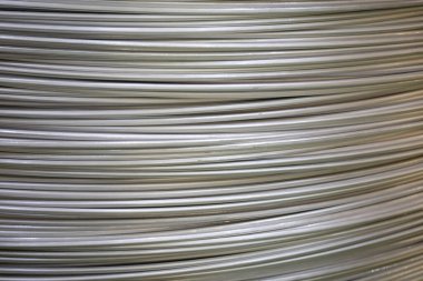 Pürüzsüz bir yüzeye sahip sarmal alüminyum kabloların yakın çekimi ve katmanlı örtüşen desen, yumuşak ışıklandırma.