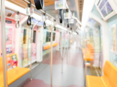 Parlak sarı koltukları ve paslanmaz çelik direkleriyle metro içi boş bir metro manzarası. Modern tren vagonu iyi ışıklandırılmış, üst kulpları ve pürüzsüz, temiz zeminleri var, hareket halindeki toplu taşımayı öneriyor..