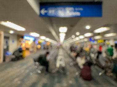 Havaalanının iç kısmının bulanık görüntüsü, hafif ışıklandırma, oturma alanları ve sakin, bastırılmış bir atmosferi var..