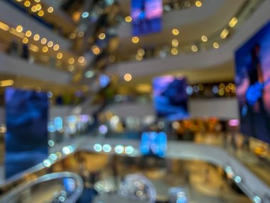Hareketli bir alışveriş merkezinin bulanık görüntüsü modern bir perakende satış ortamının canlı atmosferini yakalıyor. İnsanlar alışveriş yaparken görülüyor.