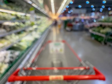 Raflarda çeşitli taze meyve ve sebzelerin sergilendiği bir market üretim bölümünün bulanık görüntüsü. Resim ürünün canlı renklerini ve dokularını yakalar