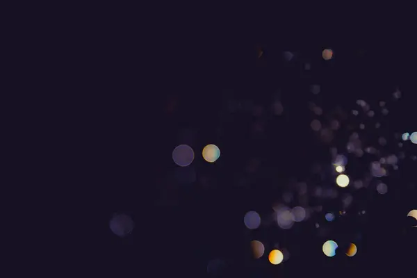 Karanlık arka planda renkli daireleri olan soyut sahte ışıklar, rüya gibi ve şenlikli bir atmosfer yaratıyor.