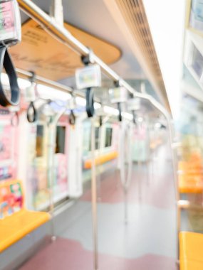 Parlak sarı koltukları ve paslanmaz çelik direkleriyle metro içi boş bir metro manzarası. Modern tren vagonu iyi ışıklandırılmış, üst kulpları ve pürüzsüz, temiz zeminleri var, hareket halindeki toplu taşımayı öneriyor..
