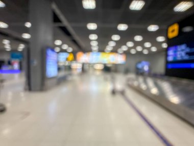 Havaalanı terminalinin bulanık görüntüsü, beklenti ve seyahat duygusunu yakalıyor. Resim boş bir bagaj teslim alanını gösteriyor