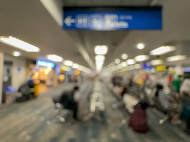 Havaalanının iç kısmının bulanık görüntüsü, hafif ışıklandırma, oturma alanları ve sakin, bastırılmış bir atmosferi var..