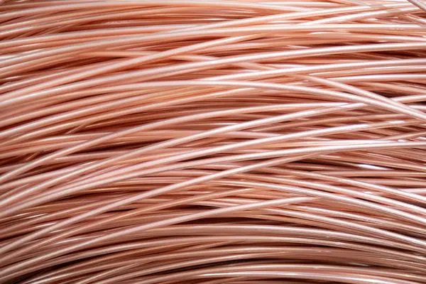 Parlak yüzeyi olan sarmalanmış bakır kabloların yakın çekimi, karmaşık örtüşen desenler, sıcak ışıklandırma..