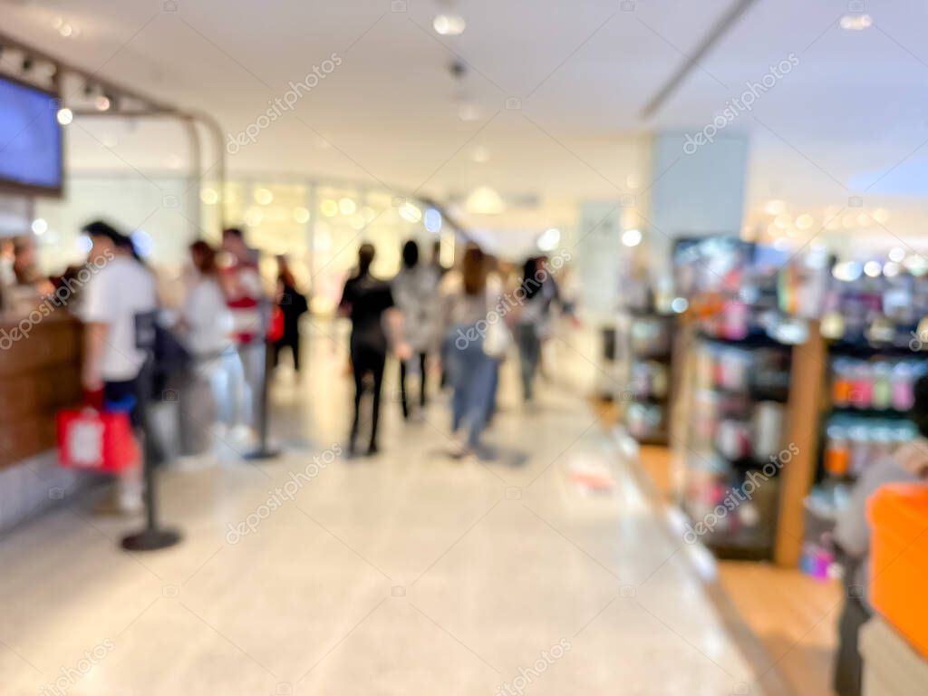 Blurred image of a bustling shopping mall, capturing the vibrant atmosphere of a modern retail environment. People are seen shopping