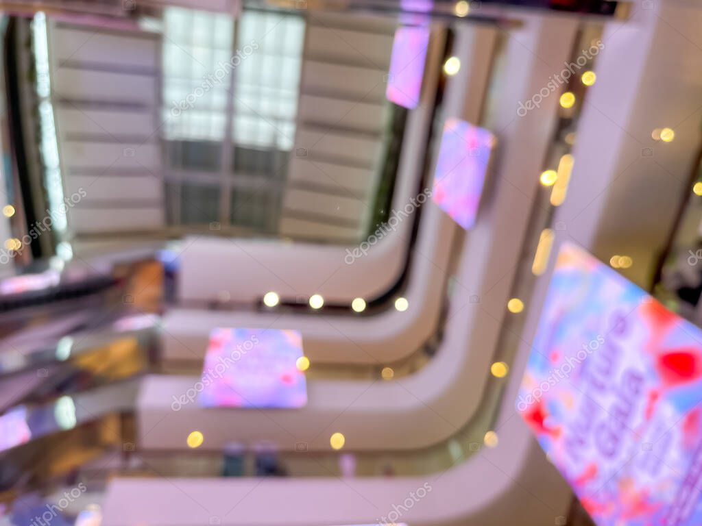 Blurred image of a bustling shopping mall, capturing the vibrant atmosphere of a modern retail environment. People are seen shopping