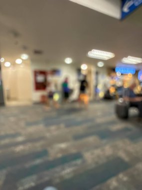 Havaalanının iç kısmının bulanık görüntüsü, hafif ışıklandırma, oturma alanları ve sakin, bastırılmış bir atmosferi var..