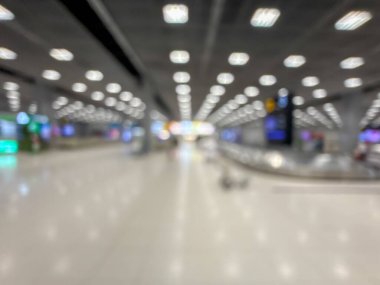 Havaalanı terminalinin bulanık görüntüsü, beklenti ve seyahat duygusunu yakalıyor. Resim boş bir bagaj teslim alanını gösteriyor