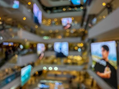 Hareketli bir alışveriş merkezinin bulanık görüntüsü modern bir perakende satış ortamının canlı atmosferini yakalıyor. İnsanlar alışveriş yaparken görülüyor.