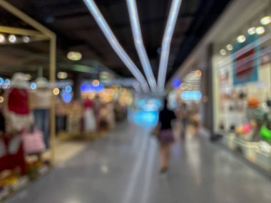 Hareketli bir alışveriş merkezinin bulanık görüntüsü modern bir perakende satış ortamının canlı atmosferini yakalıyor. İnsanlar yürürken, alışveriş yaparken ve eğlenirken görülürler.