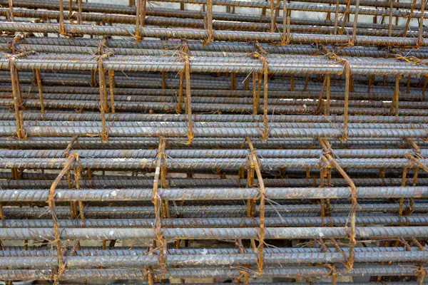 İnşaatta beton takviyesi için kullanılan çelik inşaat ızgarasına yakın çekim. Dayanıklılık için gerekli olan paslı çubuk deseni gösteriliyor.