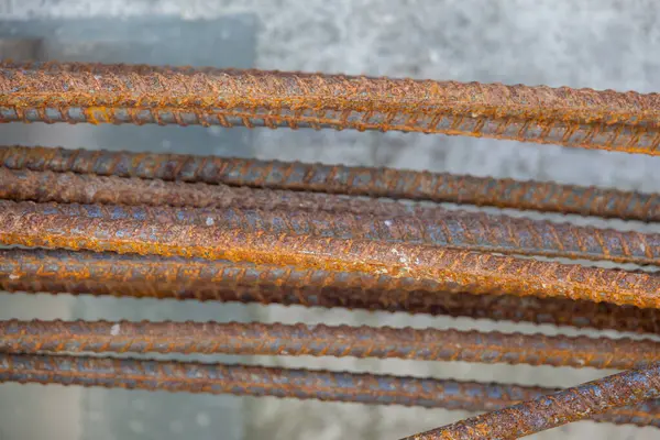 İnşaat için hazırlanmış çelik bir demir kafesi olan beton bir temele yakın çekim. İnşaat desteğinin ilk aşamasını gösterir