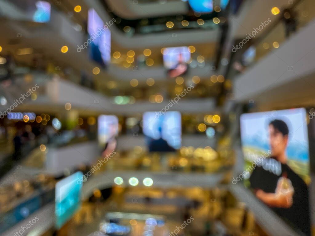 Blurred image of a bustling shopping mall, capturing the vibrant atmosphere of a modern retail environment. People are seen shopping