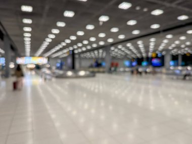 Havaalanı terminalinin bulanık görüntüsü, beklenti ve seyahat duygusunu yakalıyor. Resim boş bir bagaj teslim alanını gösteriyor