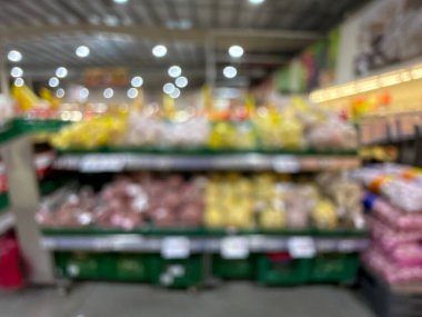 Raflarda çeşitli taze meyve ve sebzelerin sergilendiği bir market üretim bölümünün bulanık görüntüsü. Resim ürünün canlı renklerini ve dokularını yakalar