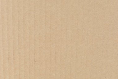 Dikey çıkıntıları ve ince gölgeleme ile desenli bej kıvrımlı karton yüzey.