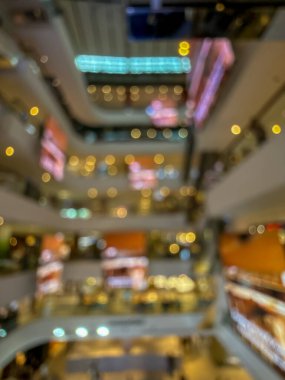 Hareketli bir alışveriş merkezinin bulanık görüntüsü modern bir perakende satış ortamının canlı atmosferini yakalıyor. İnsanlar alışveriş yaparken görülüyor.