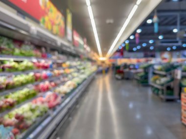 Raflarda çeşitli taze meyve ve sebzelerin sergilendiği bir market üretim bölümünün bulanık görüntüsü. Resim ürünün canlı renklerini ve dokularını yakalar