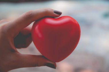 Kadın arka plan için kırmızı kalp kullanım tutun