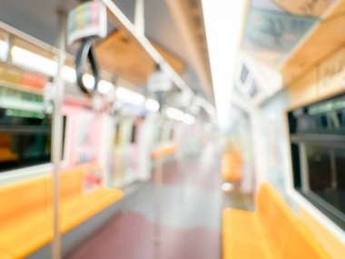 Parlak sarı koltukları ve paslanmaz çelik direkleriyle metro içi boş bir metro manzarası. Modern tren vagonu iyi ışıklandırılmış, üst kulpları ve pürüzsüz, temiz zeminleri var, hareket halindeki toplu taşımayı öneriyor..