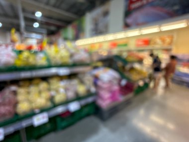 Raflarda çeşitli taze meyve ve sebzelerin sergilendiği bir market üretim bölümünün bulanık görüntüsü. Resim ürünün canlı renklerini ve dokularını yakalar
