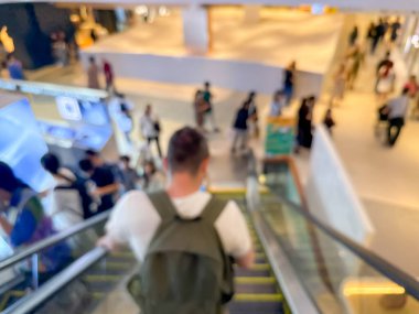 Hareketli bir alışveriş merkezinin bulanık görüntüsü modern bir perakende satış ortamının canlı atmosferini yakalıyor. İnsanlar alışveriş yaparken görülüyor.