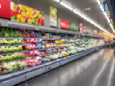 Raflarda çeşitli taze meyve ve sebzelerin sergilendiği bir market üretim bölümünün bulanık görüntüsü. Resim ürünün canlı renklerini ve dokularını yakalar