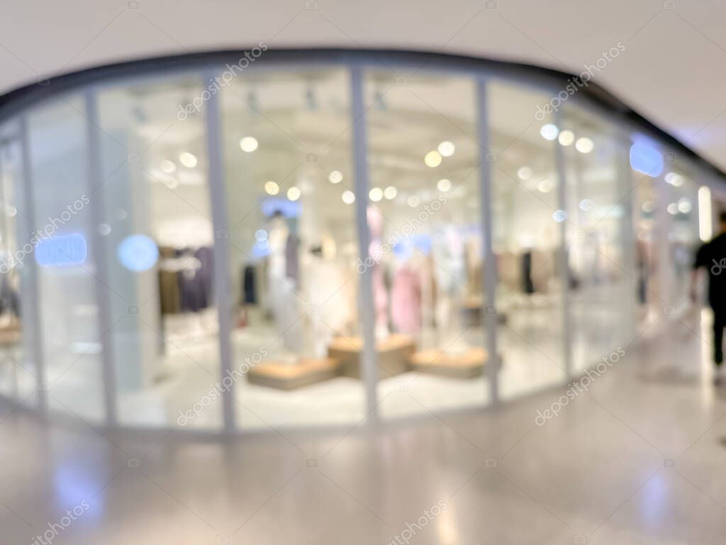 Blurred image of a bustling shopping mall, capturing the vibrant atmosphere of a modern retail environment. People are seen shopping