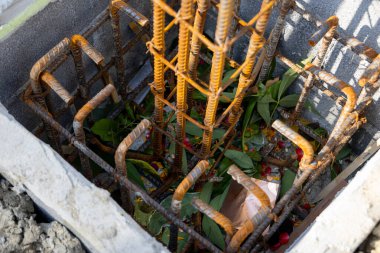 İnşaat için hazırlanmış çelik bir demir kafesi olan beton bir temele yakın çekim. İnşaat desteğinin ilk aşamasını gösterir