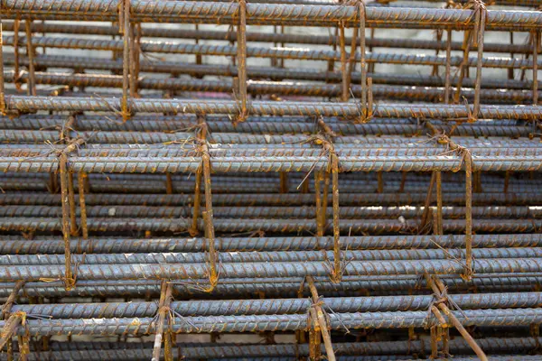 İnşaatta beton takviyesi için kullanılan çelik inşaat ızgarasına yakın çekim. Dayanıklılık için gerekli olan paslı çubuk deseni gösteriliyor.