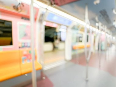Parlak sarı koltukları ve paslanmaz çelik direkleriyle metro içi boş bir metro manzarası. Modern tren vagonu iyi ışıklandırılmış, üst kulpları ve pürüzsüz, temiz zeminleri var, hareket halindeki toplu taşımayı öneriyor..