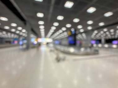 Havaalanı terminalinin bulanık görüntüsü, beklenti ve seyahat duygusunu yakalıyor. Resim boş bir bagaj teslim alanını gösteriyor