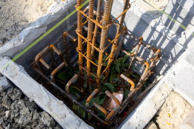 İnşaat için hazırlanmış çelik bir demir kafesi olan beton bir temele yakın çekim. İnşaat desteğinin ilk aşamasını gösterir