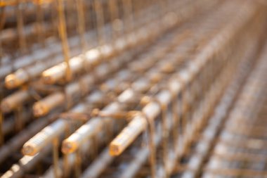 İnşaatta beton takviyesi için kullanılan çelik inşaat ızgarasına yakın çekim. Dayanıklılık için gerekli olan paslı çubuk deseni gösteriliyor.