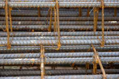 İnşaatta beton takviyesi için kullanılan çelik inşaat ızgarasına yakın çekim. Dayanıklılık için gerekli olan paslı çubuk deseni gösteriliyor.