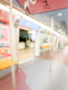 Parlak sarı koltukları ve paslanmaz çelik direkleriyle metro içi boş bir metro manzarası. Modern tren vagonu iyi ışıklandırılmış, üst kulpları ve pürüzsüz, temiz zeminleri var, hareket halindeki toplu taşımayı öneriyor..