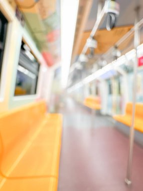 Parlak sarı koltukları ve paslanmaz çelik direkleriyle metro içi boş bir metro manzarası. Modern tren vagonu iyi ışıklandırılmış, üst kulpları ve pürüzsüz, temiz zeminleri var, hareket halindeki toplu taşımayı öneriyor..