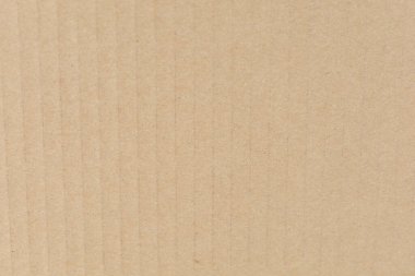 Dikey çıkıntıları ve ince gölgeleme ile desenli bej kıvrımlı karton yüzey.