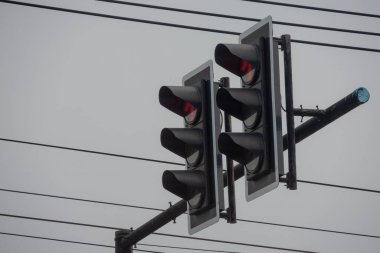 Kırmızı gösteren iki trafik ışığı sinyalinin yakından görüntüsü. Aydınlatılmış kırmızı ışıklar araç trafiği için 