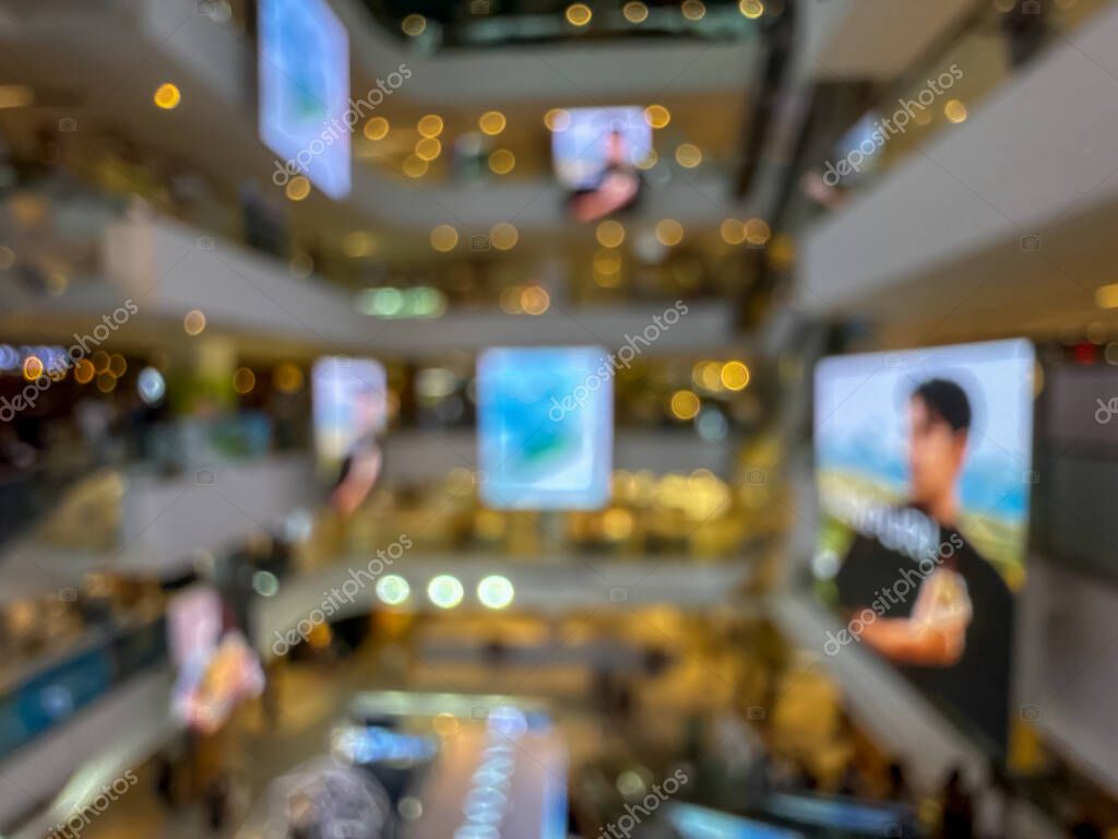 Blurred image of a bustling shopping mall, capturing the vibrant atmosphere of a modern retail environment. People are seen shopping