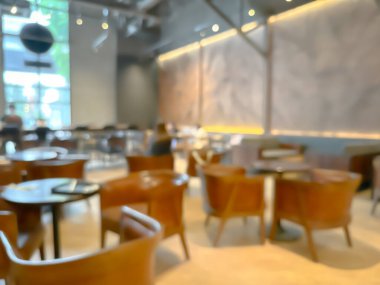 Ahşap sandalyeli, masalı, sıcak ışıklandırmalı ve büyük pencereli modern bir kafe.